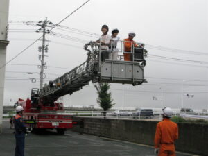 消火訓練でのはしご車試乗体験の写真です。さあ、はしご車が伸び始めます